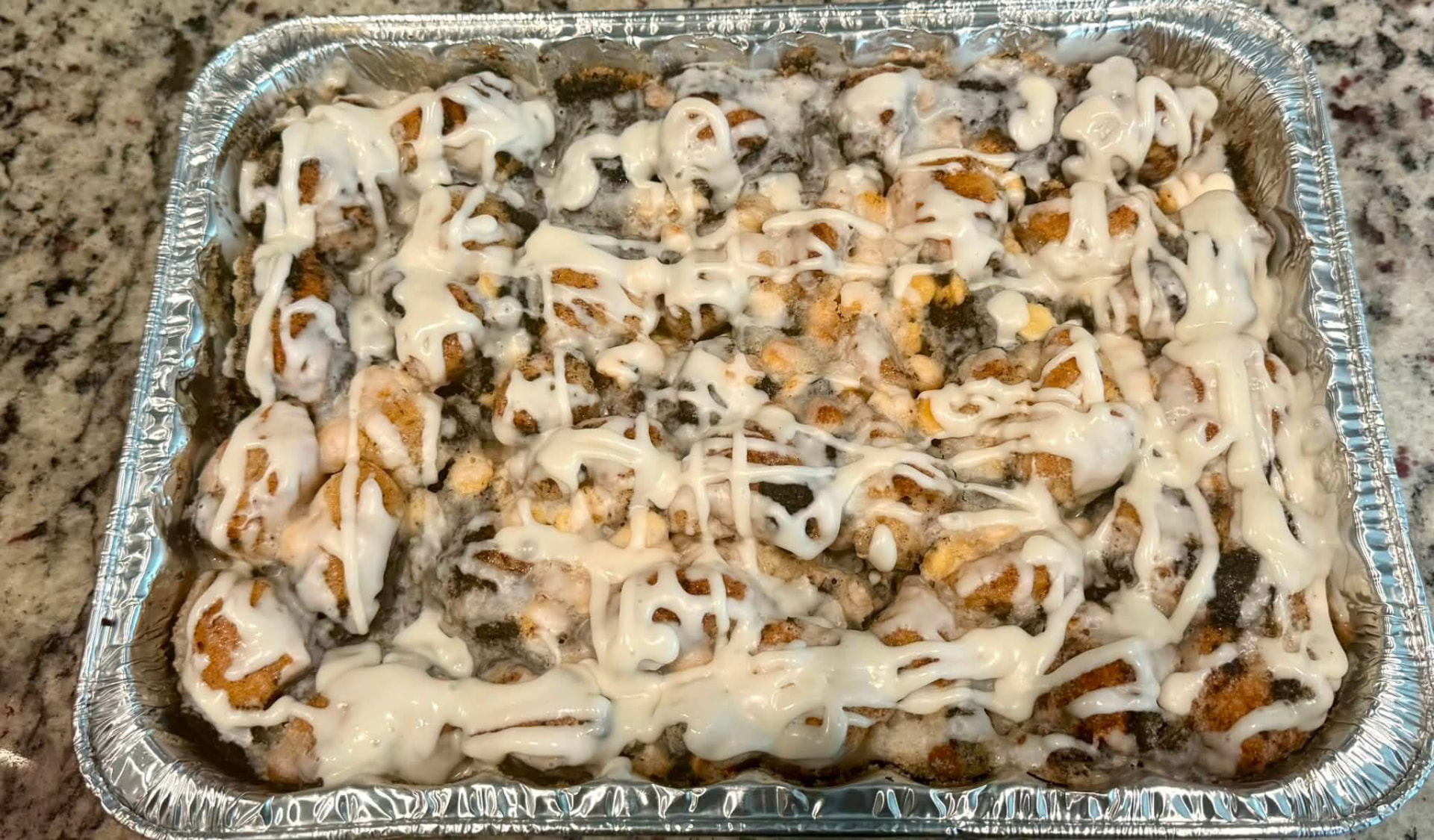 Cookies & cream monkey bread half pan with cookie crumbles and vanilla drizzle