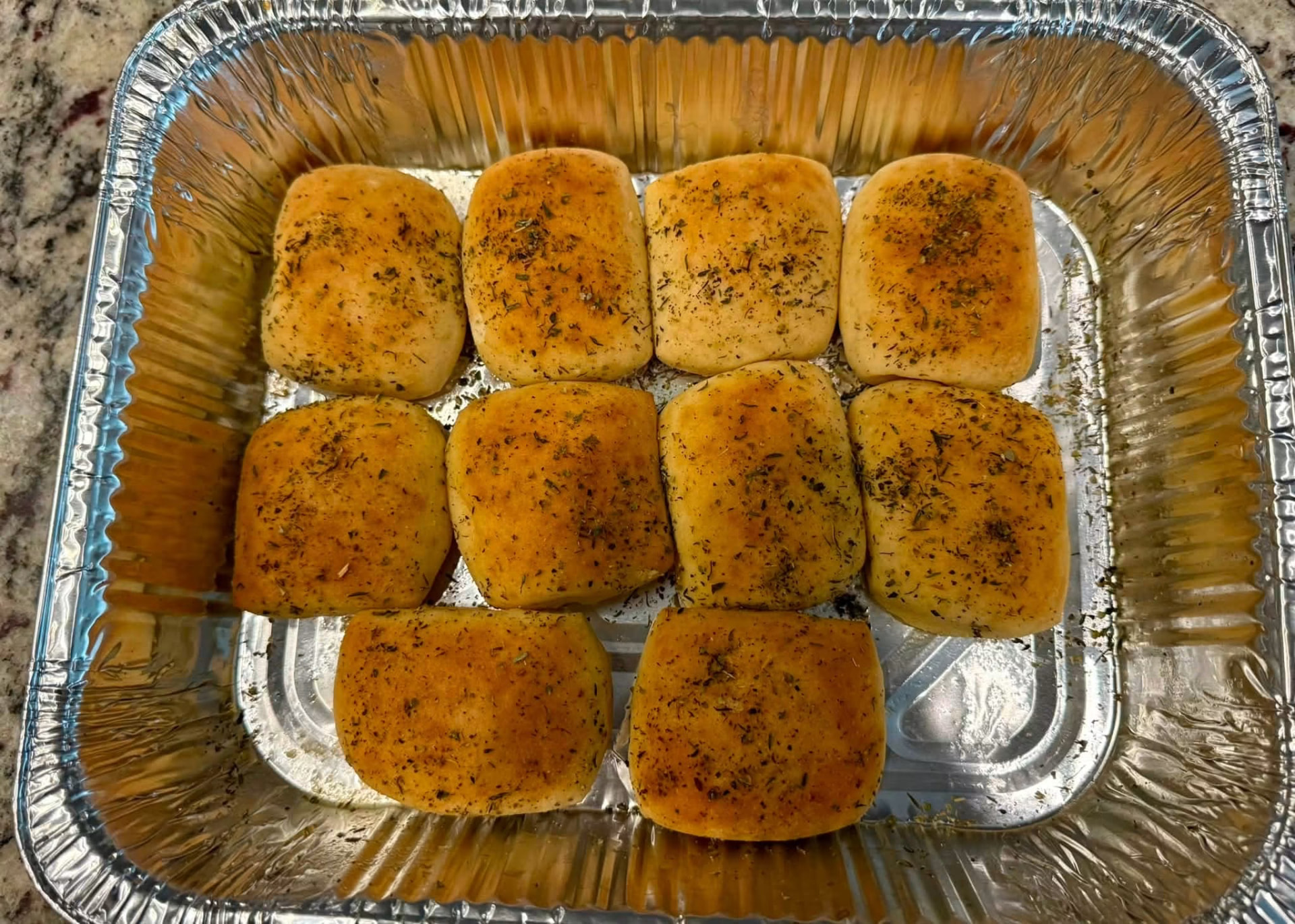 Herb-buttered dinner rolls in a catering pan